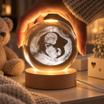 Hand hält beleuchtete Kristallkugel mit graviertem Ultraschallbild